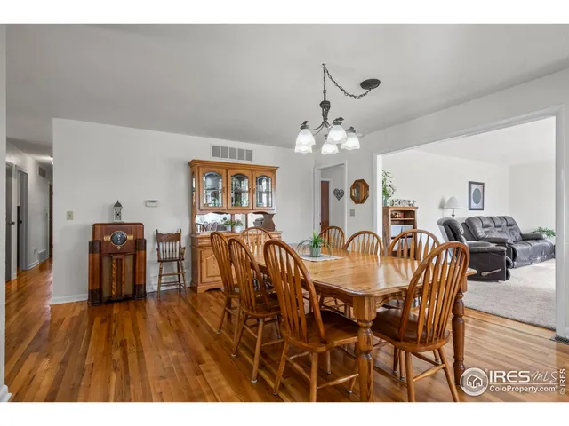 a dining room with furniture a chandelier and wooden floor