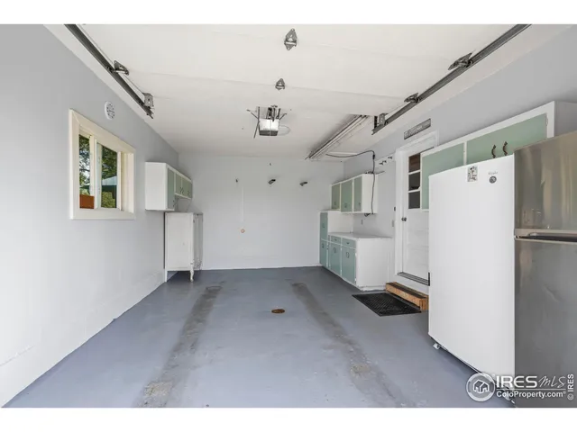a view of a storage & utility room with a refrigerator