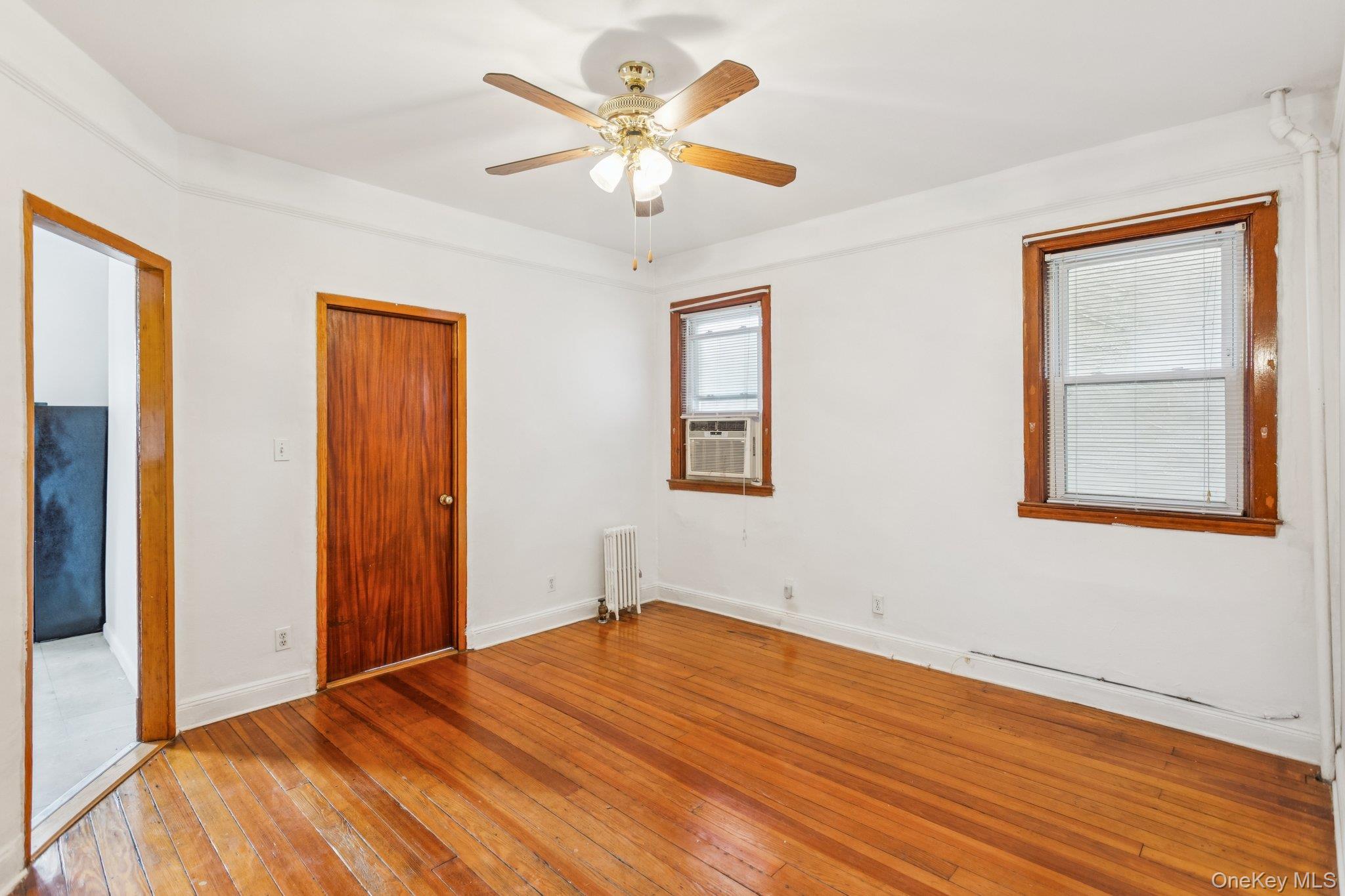45-09 104th Street Queens, NY 11368 - Photo 8 of 21 a view of empty room with wooden floor and fan