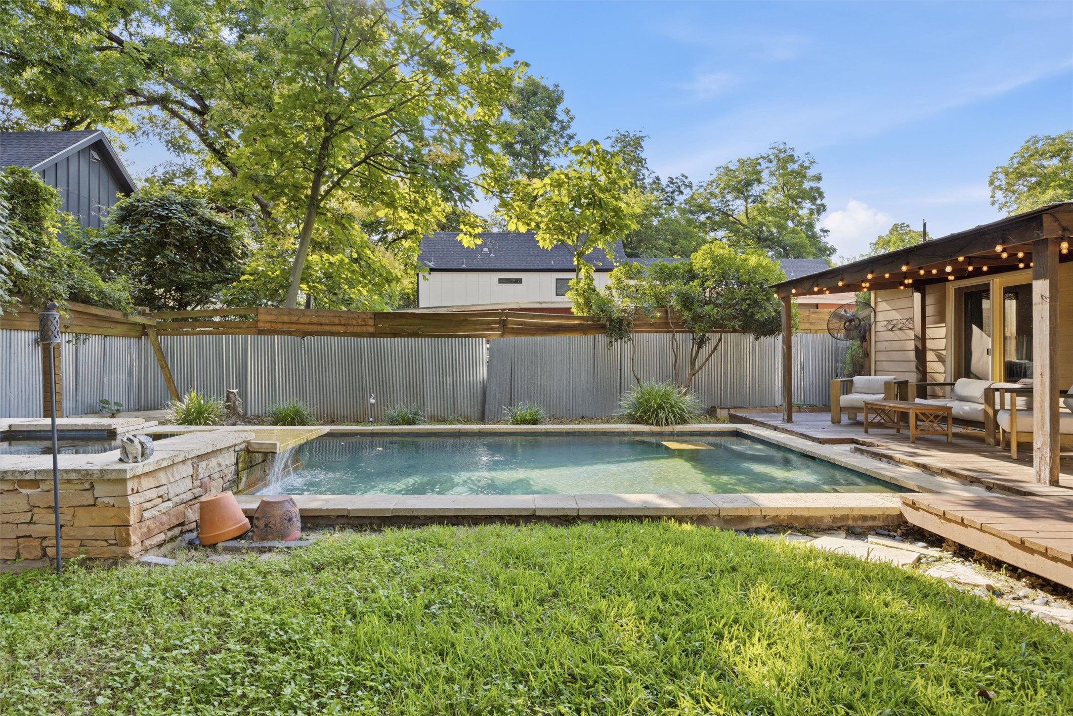 3015 Castro Street Austin, TX 78702 - Photo 40 of 40 An inviting backyard oasis offers a serene pool with a waterfall feature, complemented by a cozy outdoor living area.