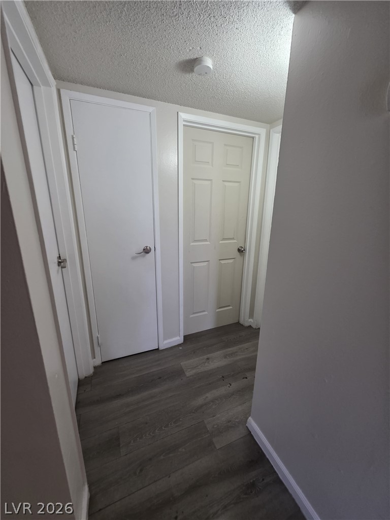 1075 East Desert Inn Road, Unit 5 Las Vegas, NV 89109 - Photo 9 of 12 Clean and well-maintained hallway with durable wood-look flooring and multiple access points.