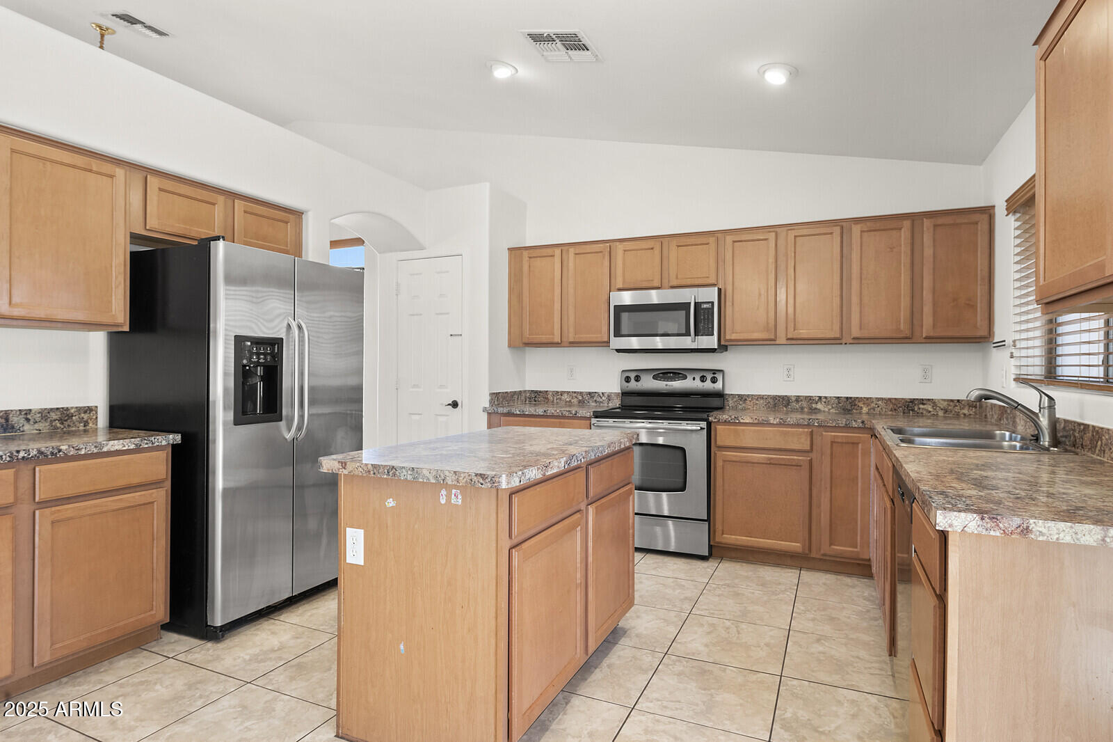 3297 East Warbler Road Gilbert, AZ 85297 - Photo 9 of 32 a kitchen with stainless steel appliances granite countertop a refrigerator stove and a sink