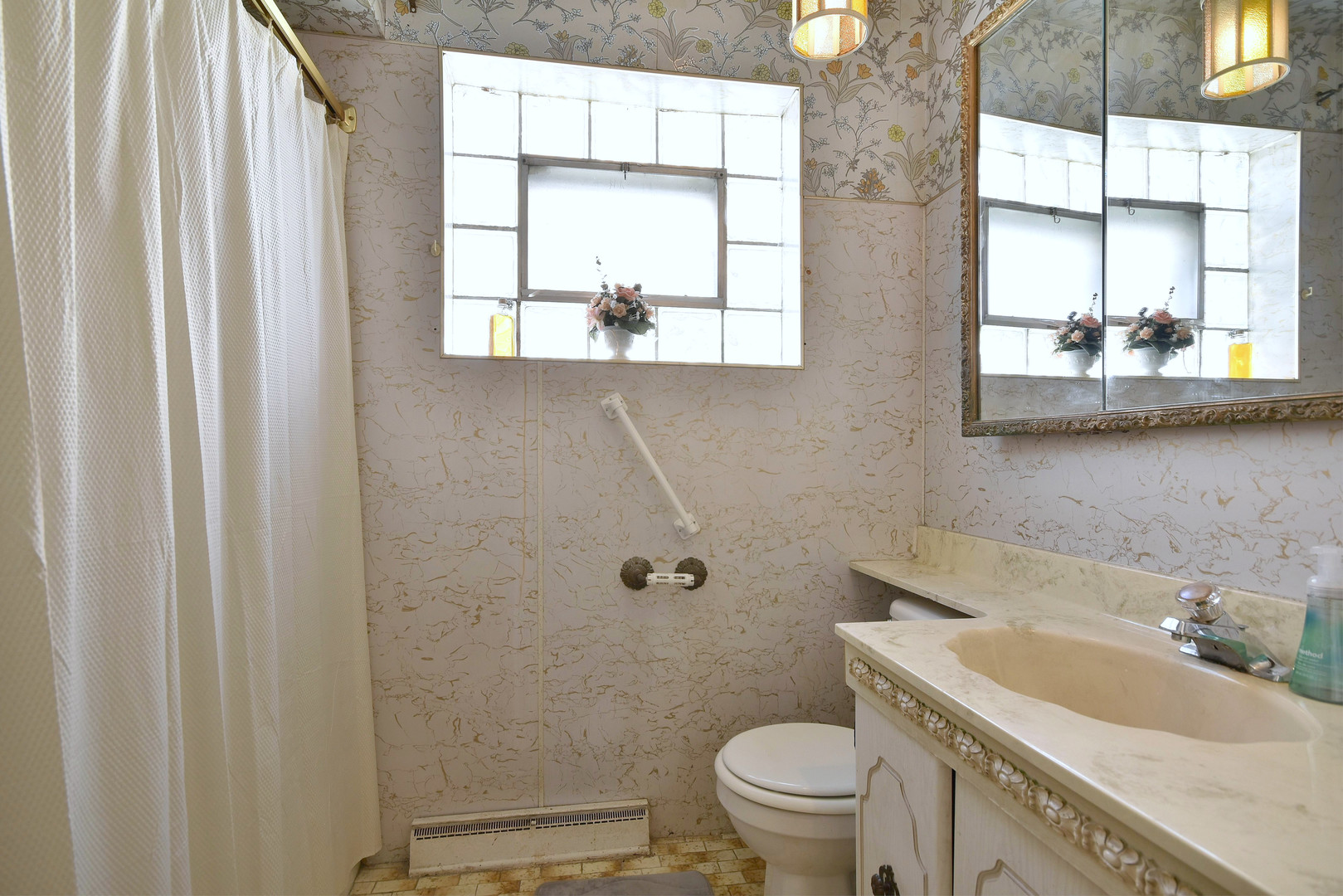 7555 Monroe Street Niles, IL 60714 - Photo 13 of 41 a bathroom with a granite countertop toilet a sink and a window