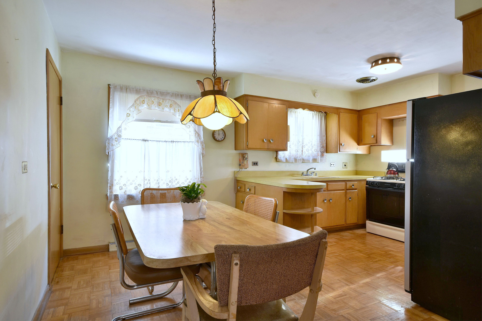 7555 Monroe Street Niles, IL 60714 - Photo 14 of 41 a kitchen with a table chairs sink and refrigerator