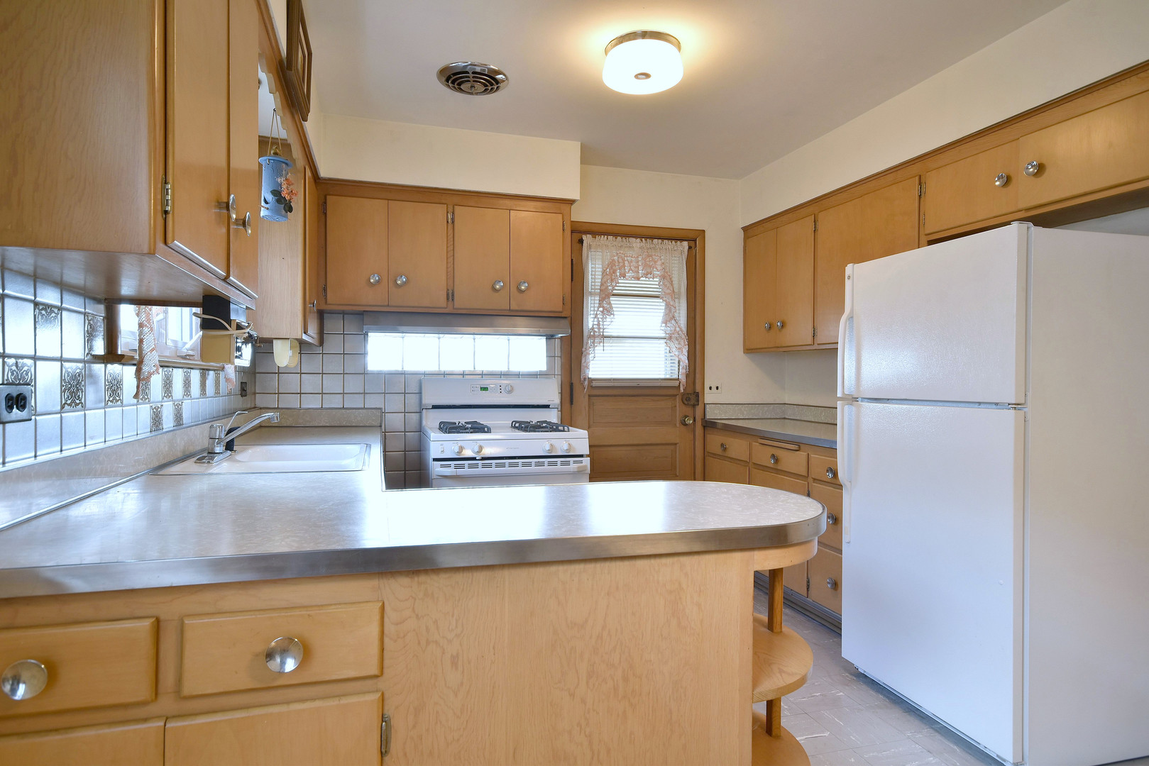 7555 Monroe Street Niles, IL 60714 - Photo 31 of 41 a kitchen with stainless steel appliances granite countertop a refrigerator a stove and a sink with wooden floors
