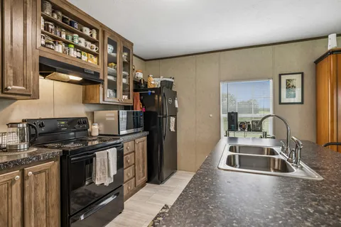 a kitchen that has a sink wooden cabinets and stainless steel appliances