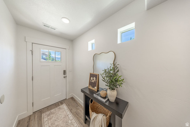 4991 South 475 West Washington Terrace, UT 84405 - Photo 7 of 31 Entryway with a white paneled door featuring multiple glass lites, LVP flooring, two high-set square windows, recessed ceiling lighting, and light color walls.