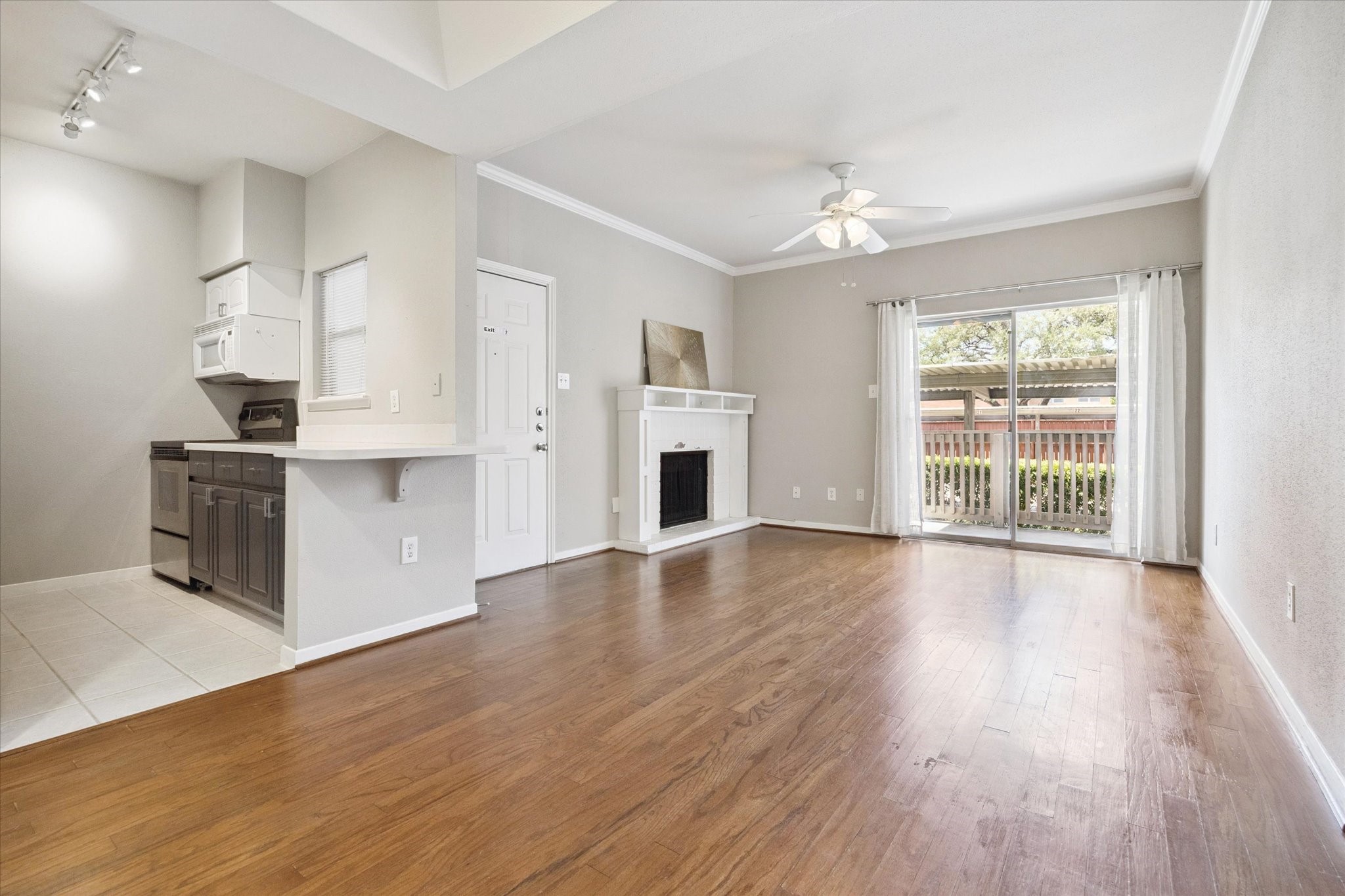 4041 Drake Street, Unit 113 Houston, TX 77005 - Photo 4 of 16 an empty room with wooden floor fireplace and windows
