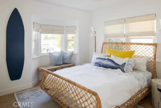 a bedroom with a bed a window and dresser