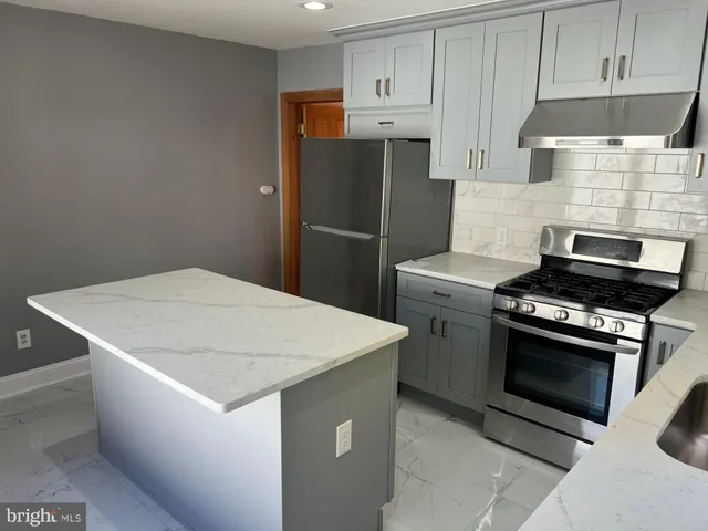 a kitchen with stainless steel appliances a refrigerator sink and stove