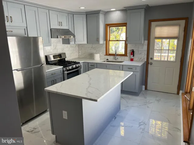 a kitchen with stainless steel appliances a refrigerator sink and stove