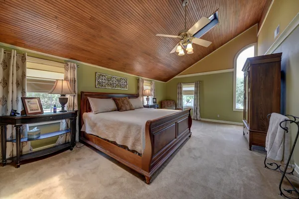 a bedroom with a bed and a mirror on the dresser