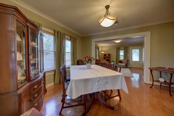 a view of a a dining room with furniture window and wooden floor