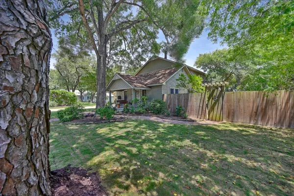 a view of a house with backyard and a tree