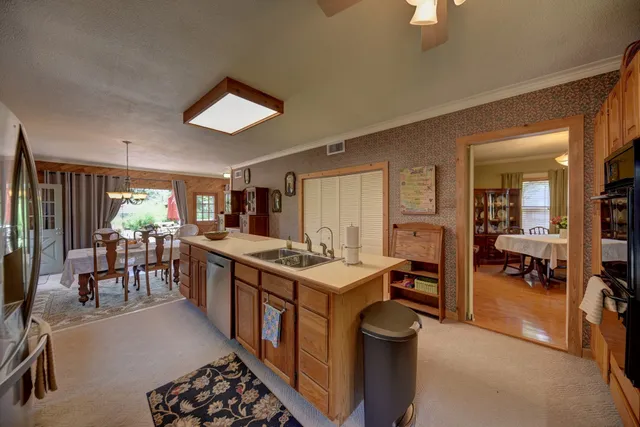 a kitchen with a sink a counter top space stainless steel appliances and cabinets