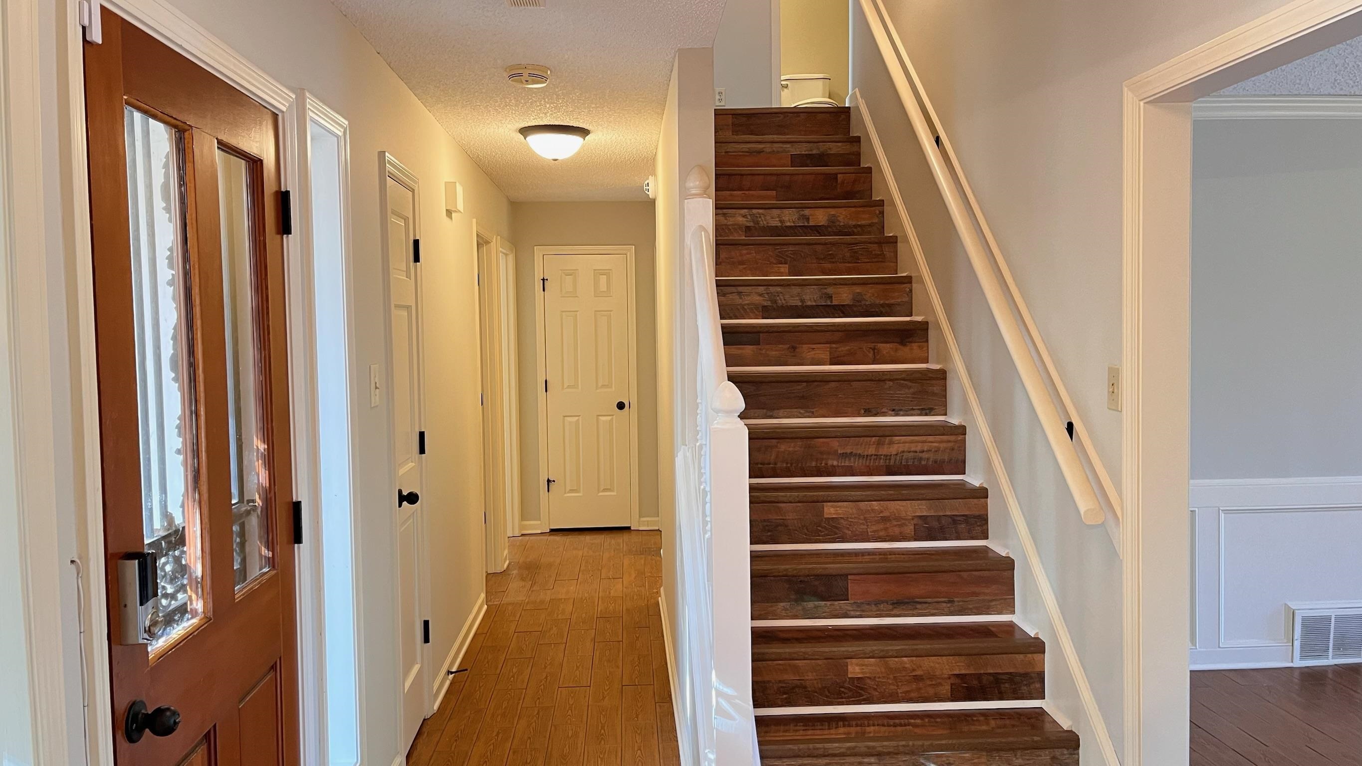 7770 Juniper Cove West Memphis, TN 38016 - Photo 20 of 34 a view of a hallway with front door wooden floor and stairs