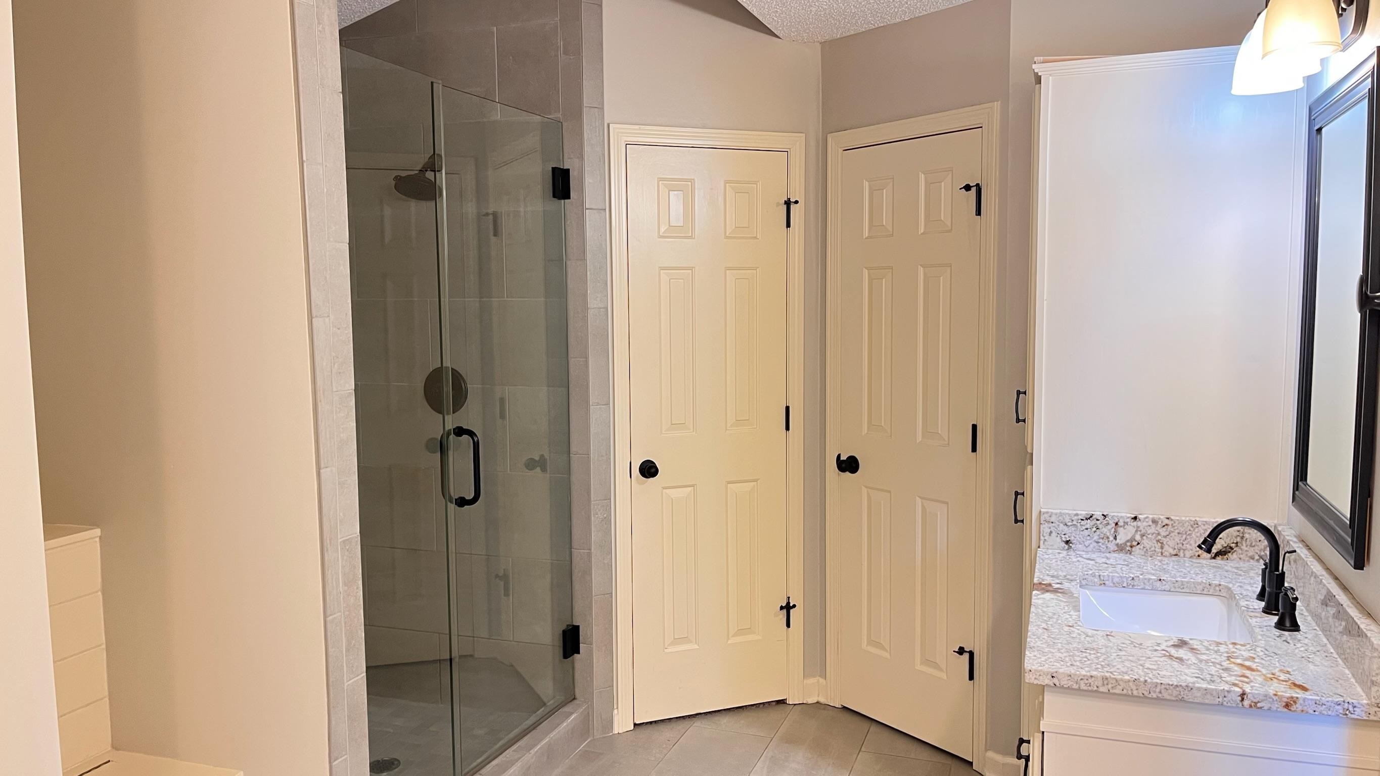 7770 Juniper Cove West Memphis, TN 38016 - Photo 22 of 34 Bathroom featuring vanity, light tile patterned flooring, a stall shower, and a textured ceiling