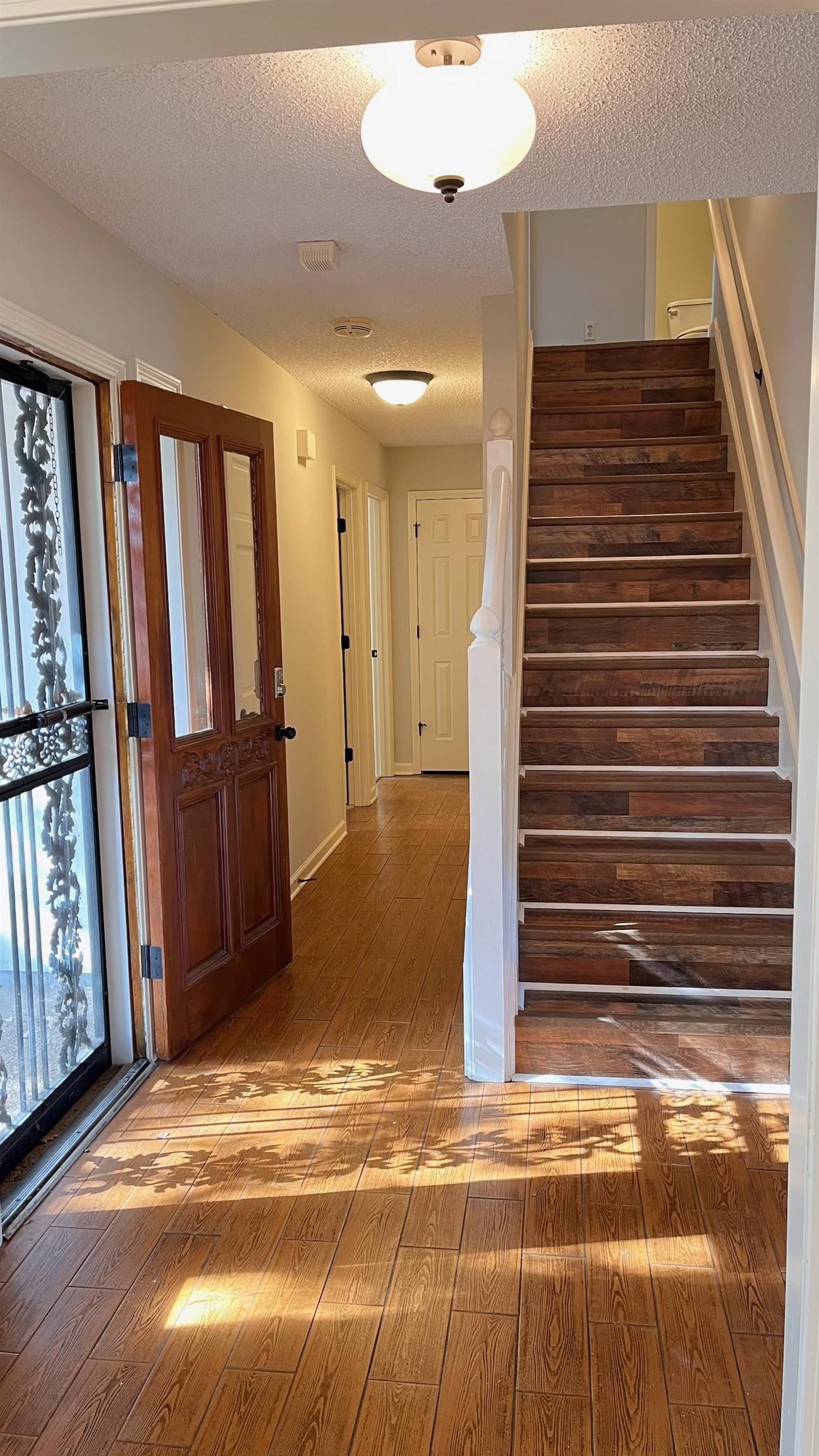 7770 Juniper Cove West Memphis, TN 38016 - Photo 6 of 34 Entrance foyer with stairs, hardwood / wood-style floors, a textured ceiling, and plenty of natural light