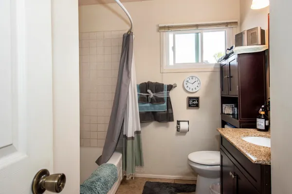a bathroom with a granite countertop toilet sink and shower