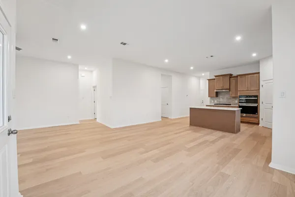 a view of kitchen with kitchen island a sink stainless steel appliances and cabinets