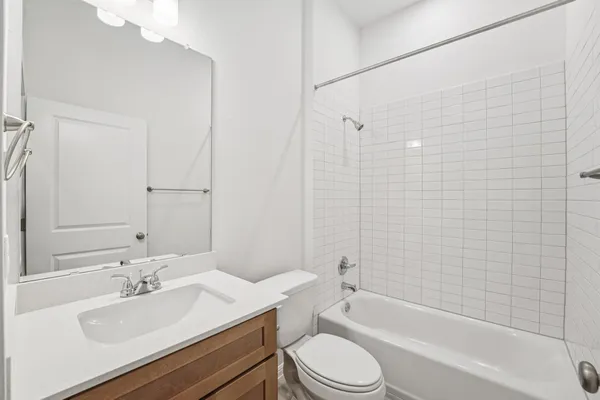 a bathroom with a granite countertop sink toilet a mirror and bathtub