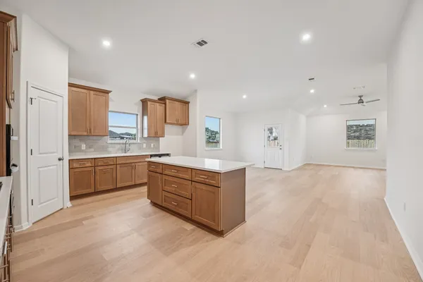 a large white kitchen with a large counter top and stainless steel appliances