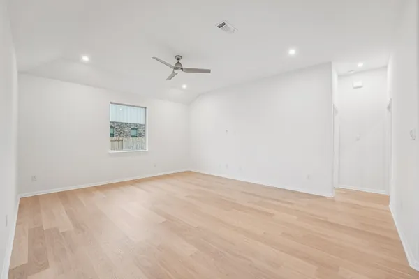 an empty room with windows and ceiling fan