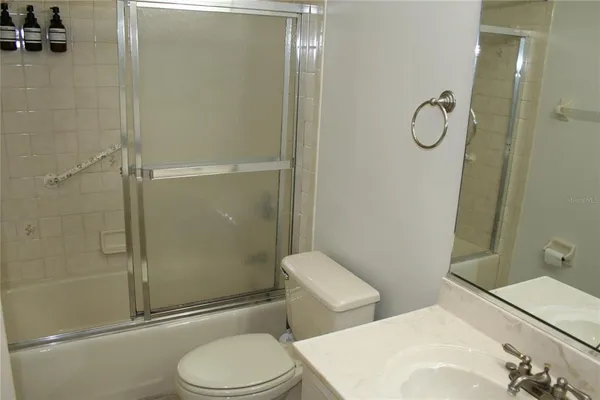 a bathroom with a toilet sink vanity and shower