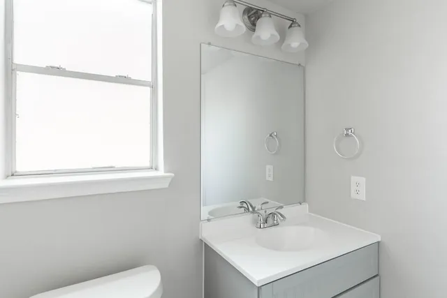 a bathroom with a sink mirror and toilet