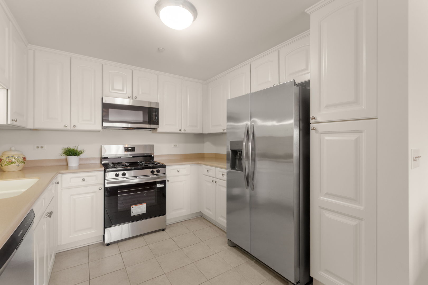 125 North Buffalo Grove Road, Unit 104 Buffalo Grove, IL 60089 - Photo 4 of 17 a kitchen with stainless steel appliances granite countertop a refrigerator stove a sink and dishwasher