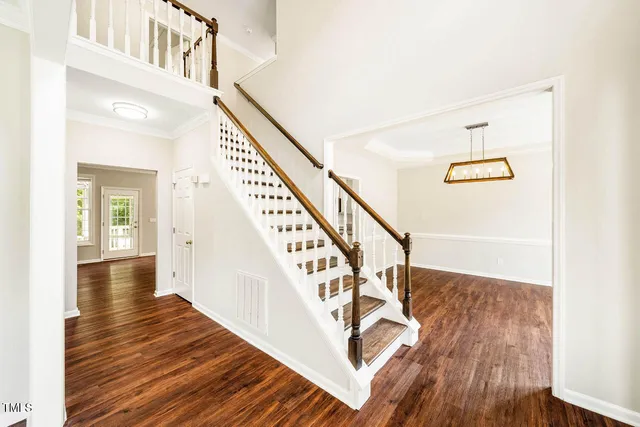 a kitchen with stainless steel appliances granite countertop a refrigerator a sink dishwasher a stove and white countertops with wooden floor