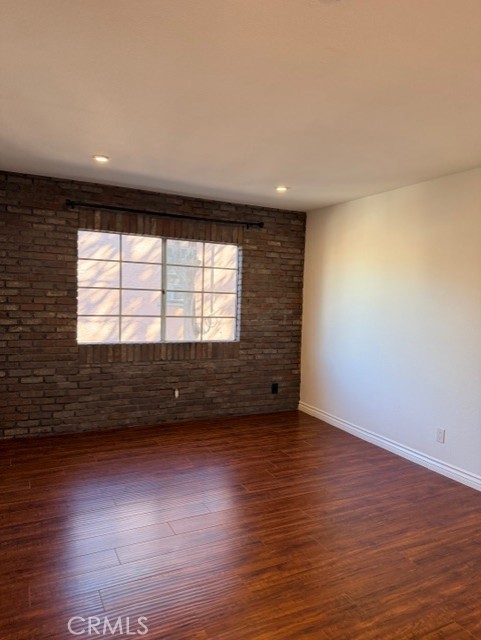 2500 East 4th Street, Unit 203 Long Beach, CA 90814 - Photo 23 of 35 a view of an empty room with wooden floor and a window