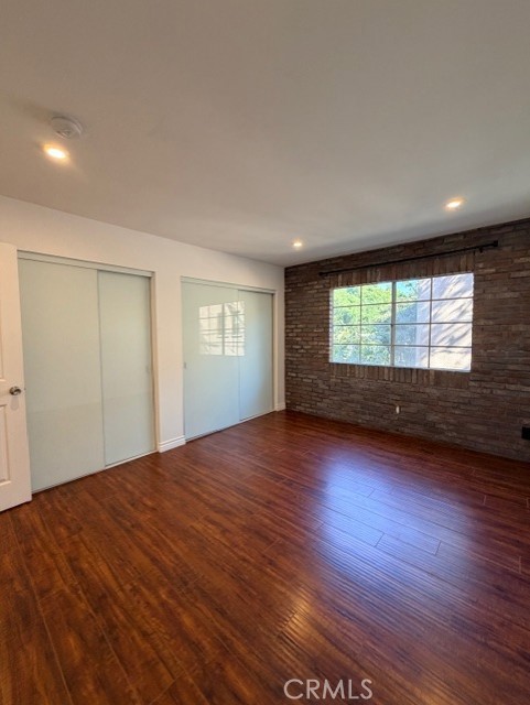 2500 East 4th Street, Unit 203 Long Beach, CA 90814 - Photo 24 of 35 a view of an empty room with a window and wooden floor