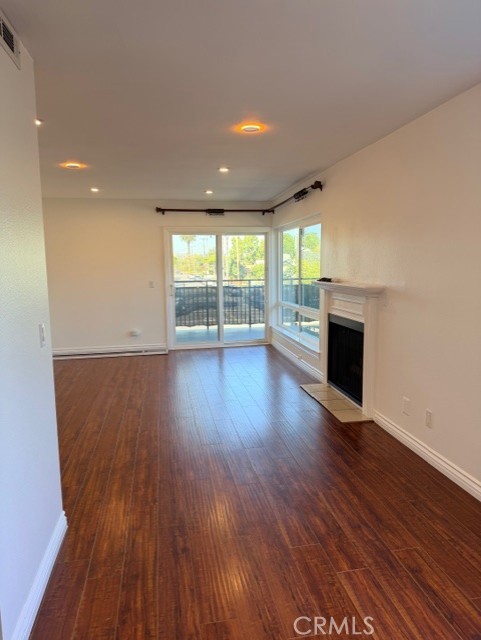 2500 East 4th Street, Unit 203 Long Beach, CA 90814 - Photo 7 of 35 an empty room with wooden floor and fireplace
