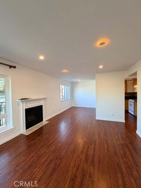 2500 East 4th Street, Unit 203 Long Beach, CA 90814 - Photo 9 of 35 an empty room with wooden floor fireplace and windows