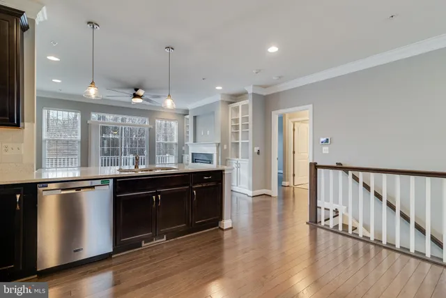 a open kitchen with stainless steel appliances granite countertop a stove and a sink with wooden floor