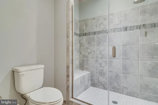 a white toilet sitting next to a bath tub and a shower