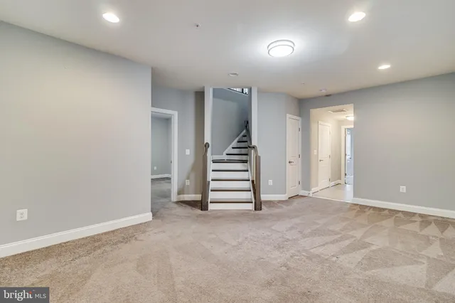 an empty room with a hallway and stairs