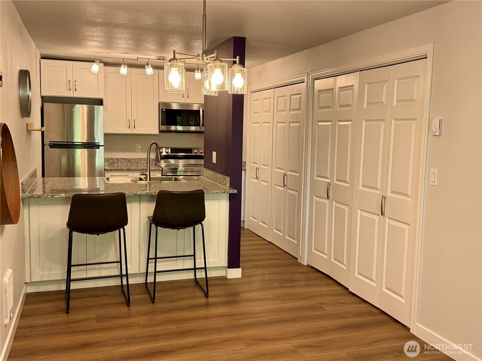 526 South 323rd Place, Unit 11F Federal Way, WA 98003 - Photo 9 of 24 a kitchen with stainless steel appliances granite countertop a stove top oven a refrigerator a dining table and chairs with wooden floor