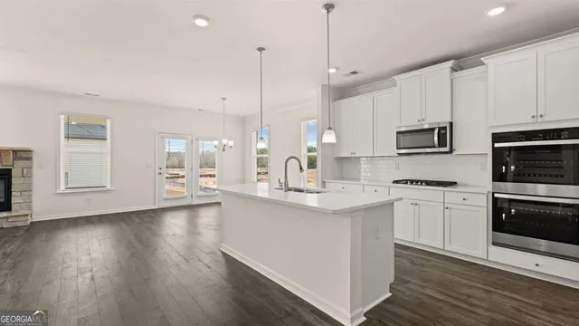 a kitchen with a sink a refrigerator and a stove top oven