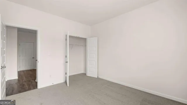 a view of a big room with wooden floor and windows