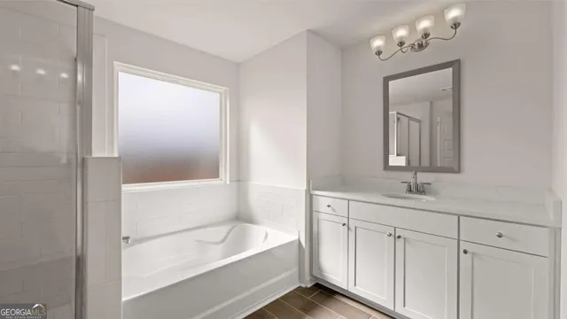 a view of an empty room with wooden floor and windows