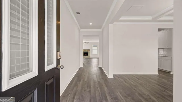 a view of a hallway with wooden floor and a chandelier