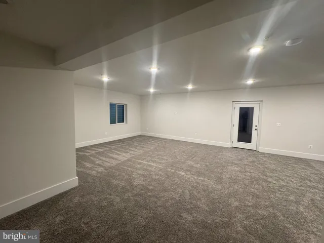 an empty room with windows and fireplace
