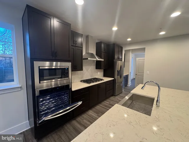 a large kitchen with a large counter top stainless steel appliances and cabinets
