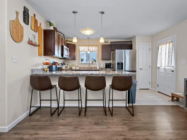 a kitchen with a dining table chairs and a wooden floor