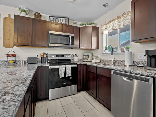 a kitchen with stainless steel appliances granite countertop a sink stove and microwave