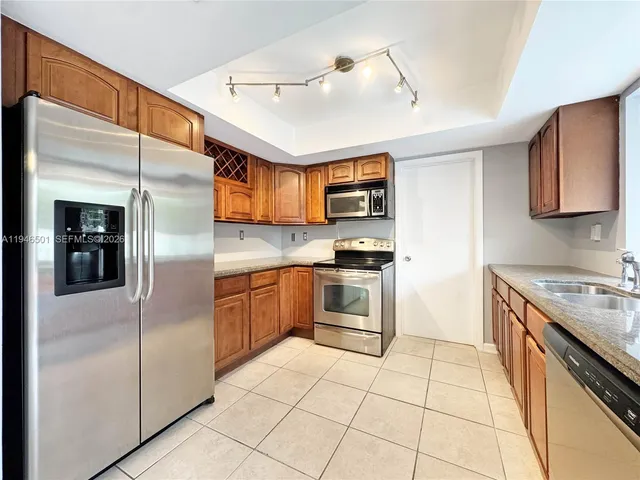 a kitchen with stainless steel appliances granite countertop a refrigerator and a stove top oven