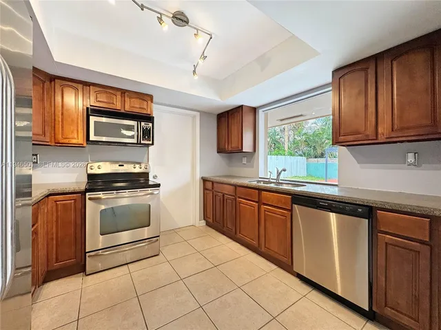 a kitchen with stainless steel appliances granite countertop a stove sink and cabinets