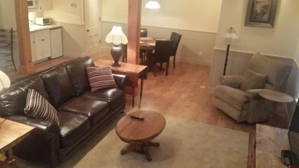 a living room with furniture and wooden floor